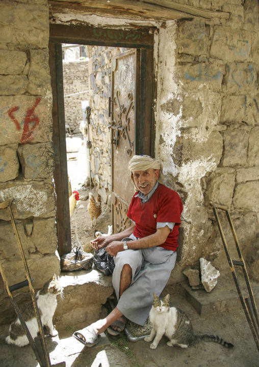 Portrait of a yemeni man fedding cats in the street, Amanat Al-Asemah, Sanaa, Yemen