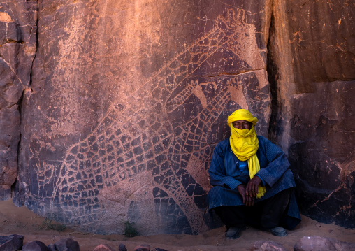 Tuareg near a rock carvings depicting giraffes, Tassili N'Ajjer National Park, Tadrart Rouge, Algeria