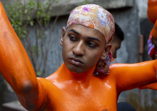 Make up of a Hindu devotee covered with orange color at Lal Kach festival, Dhaka Division, Munshiganj, Bangladesh