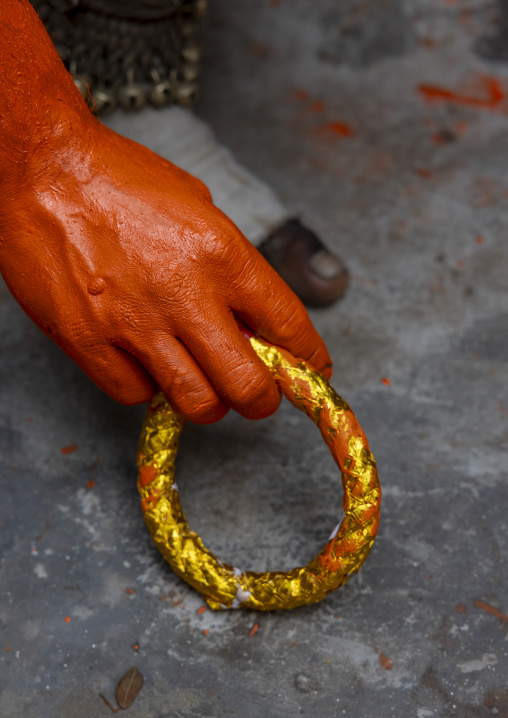 Hand and bracelet of a Hindu devotee in orange color at Lal Kach festival, Dhaka Division, Munshiganj, Bangladesh