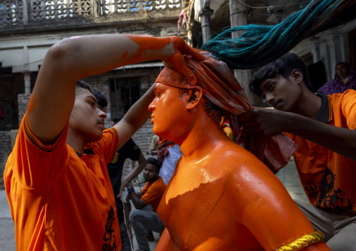 Make up of a Hindu devotee covered with orange color at Lal Kach festival, Dhaka Division, Munshiganj, Bangladesh