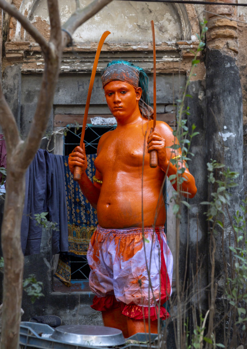 Hindu devotee with swords covered with orange color at Lal Kach festival, Dhaka Division, Munshiganj, Bangladesh