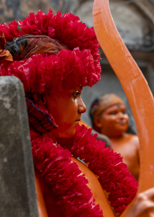 Young hindu devotees in orange color playing with swords at Lal Kach festival, Dhaka Division, Munshiganj, Bangladesh