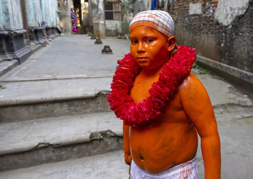 Young hindu devotee covered with orange color at Lal Kach festival, Dhaka Division, Munshiganj, Bangladesh