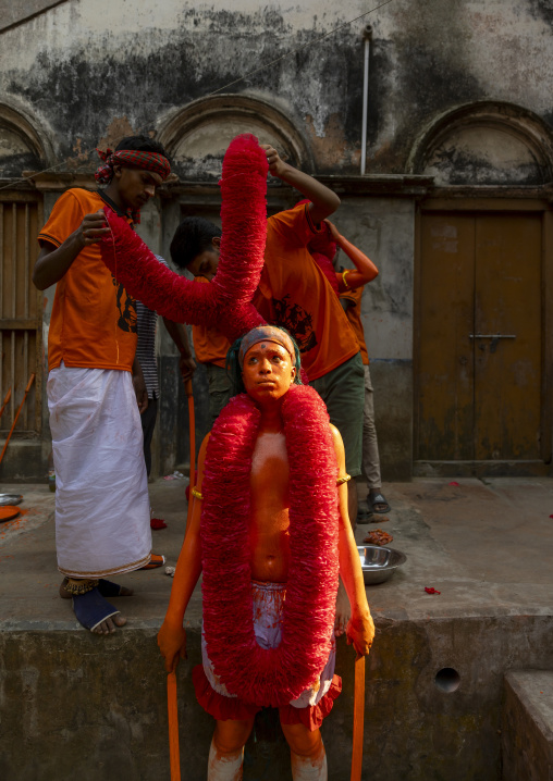 Dressing of a Hindu devotee covered with orange color at Lal Kach festival, Dhaka Division, Munshiganj, Bangladesh
