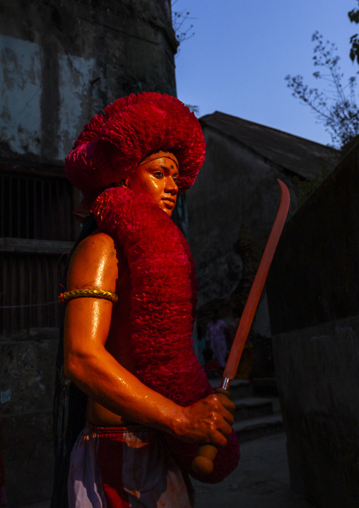 Hindu devotee with sword covered with orange color at Lal Kach festival, Dhaka Division, Munshiganj, Bangladesh