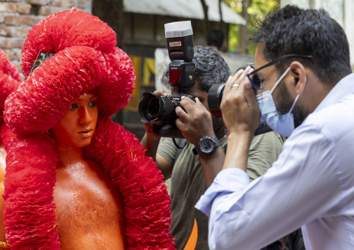 Photographers taking pictures of a hindu devotee at Lal Kach festival, Dhaka Division, Munshiganj, Bangladesh