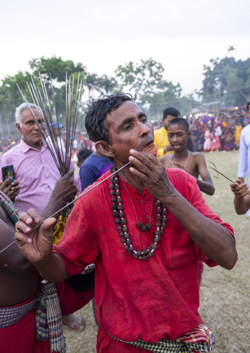 Man cleaning an iron arrow before piercing during Charak Puja hindu festival, Sylhet Division, Kamalganj, Bangladesh