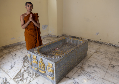Monk praying in front of a grave in Shalban Buddhist Monastery, Chittagong Division, Comilla, Bangladesh
