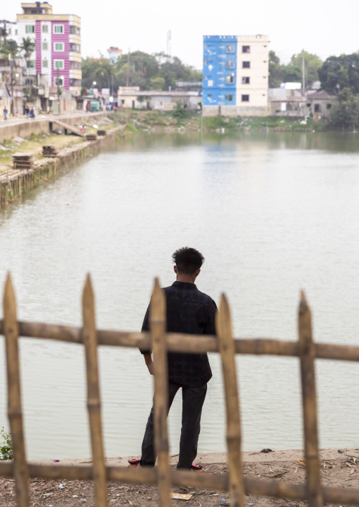 Bangladeshi man in front of a pond, Chittagong Division, Comilla, Bangladesh