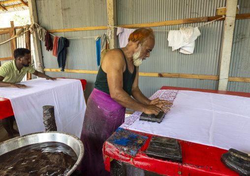 Bangladeshi man stamping wax on a cloth in a batik factory, Chittagong Division, Comilla, Bangladesh