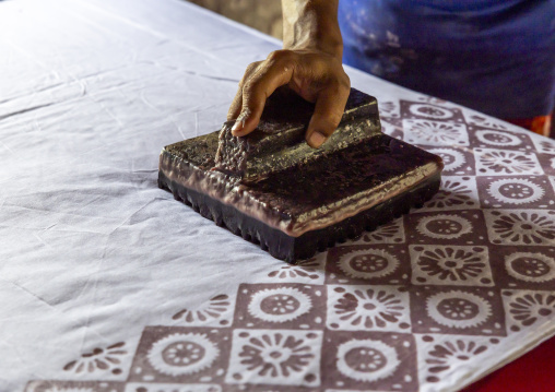 Bangladeshi man stamping wax on a cloth in a batik factory, Chittagong Division, Comilla, Bangladesh