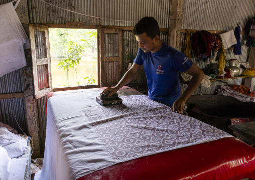 Bangladeshi man stamping wax on a cloth in a batik factory, Chittagong Division, Comilla, Bangladesh
