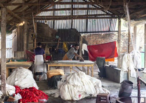 Bangladeshi men stamping wax on a cloth in a batik factory, Chittagong Division, Comilla, Bangladesh