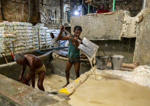 Bangladeshi men washing salt in water in a factory, Chittagong Division, Chittagong, Bangladesh