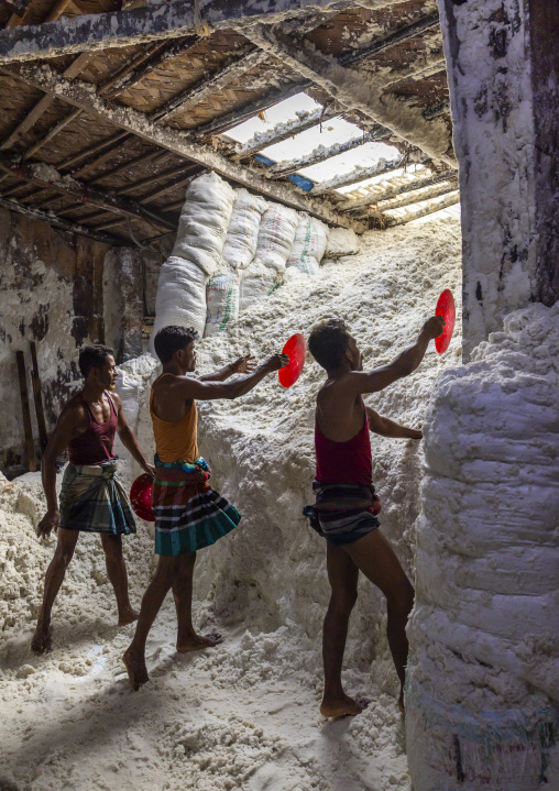 Bangladeshi men pick up salt in a warehouse, Chittagong Division, Chittagong, Bangladesh