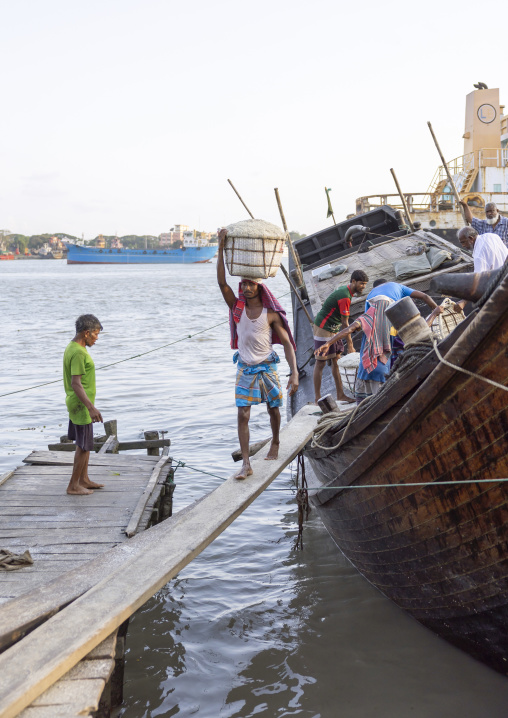 Bangladeshi men unloading salt in baskets from a boat, Chittagong Division, Chittagong, Bangladesh
