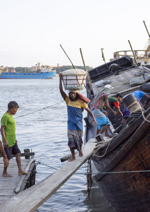 Bangladeshi men unloading salt in baskets from a boat, Chittagong Division, Chittagong, Bangladesh