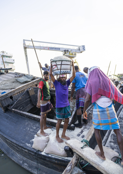 Bangladeshi men unloading salt in baskets from a boat, Chittagong Division, Chittagong, Bangladesh
