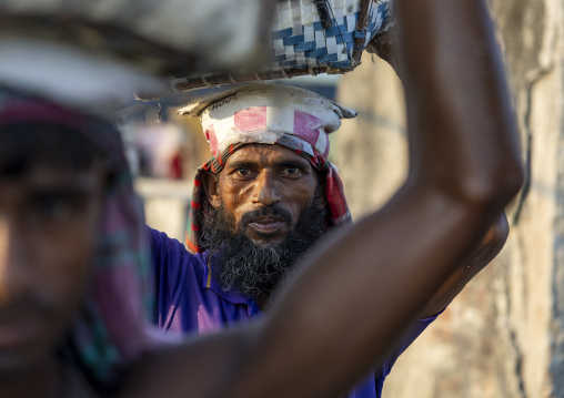 Bangladeshi men weighing baskets with salt at a factory, Chittagong Division, Chittagong, Bangladesh