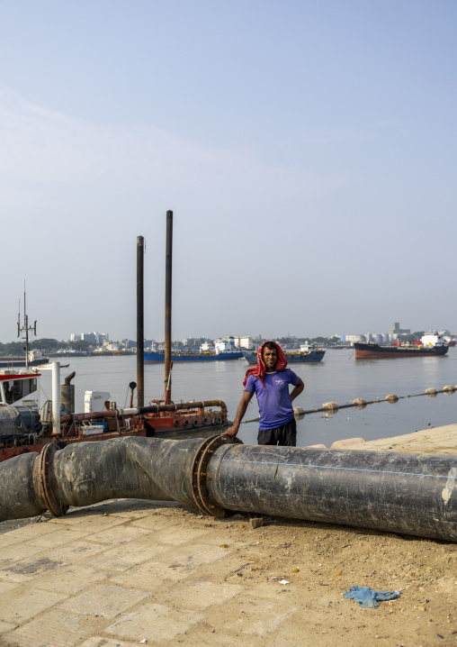 Bangladeshi man near a pipeline to bring sand in the port, Chittagong Division, Chittagong, Bangladesh