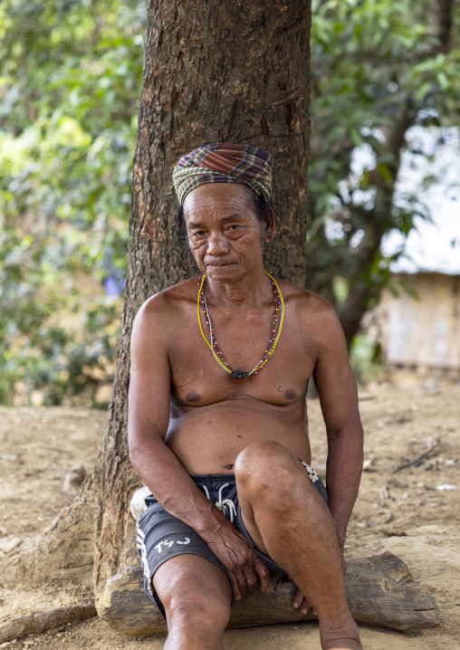 Murong ethnic group shirtless man sit against a tree, Chittagong Division, Bandarban, Bangladesh