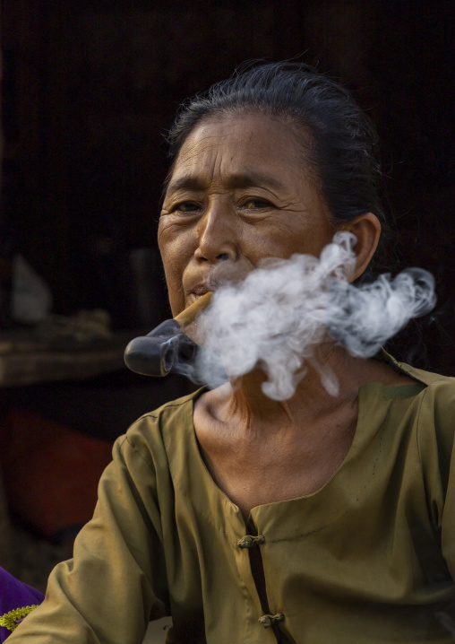 Marma woman smoking a cigar, Chittagong Division, Rowangchhari, Bangladesh