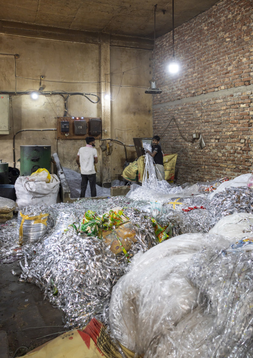 Bangladeshi men dismantling plastic bags for recycling, Dhaka Division, Dhaka, Bangladesh