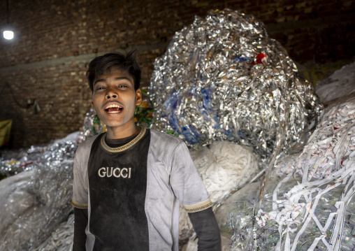 Bangladeshi teenage boy dismantling plastic bags for recycling, Dhaka Division, Dhaka, Bangladesh