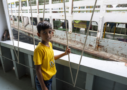 Boy on an anchored ferry vessels at the dockyard, Dhaka Division, Dhaka, Bangladesh