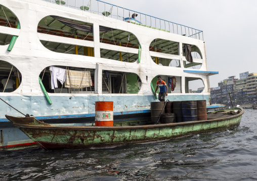 Man bringing fuel to an anchored ferry vessels at the dockyard, Dhaka Division, Dhaka, Bangladesh