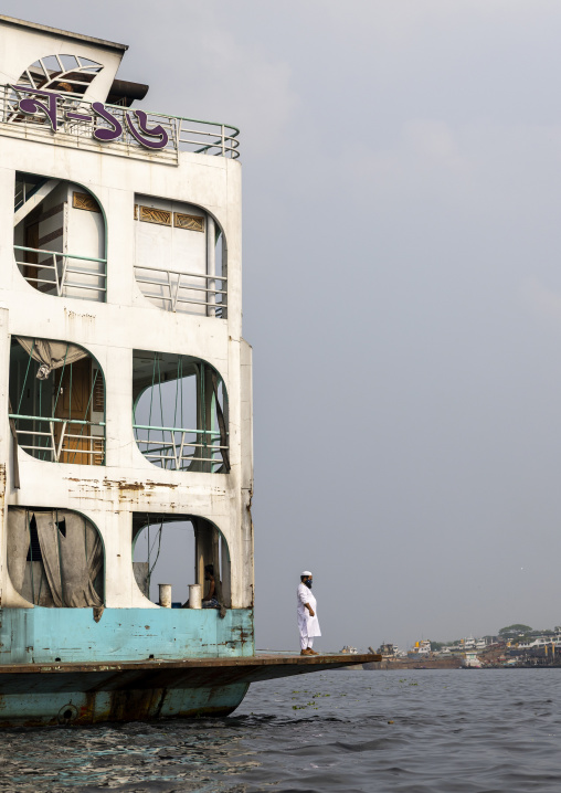 Muslim man standing on an anchored ferry vessel, Dhaka Division, Keraniganj, Bangladesh
