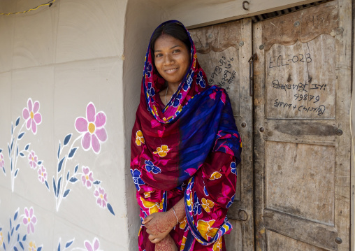 Christian woman from Santal ethnic group in front of a wall painting, Rajshahi Division, Tanore, Bangladesh