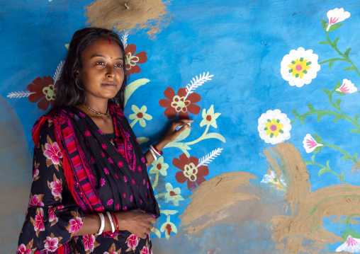 Bangladeshi teenage girl in front of a traditional wall painting in a house, Rajshahi Division, Tikoil, Bangladesh
