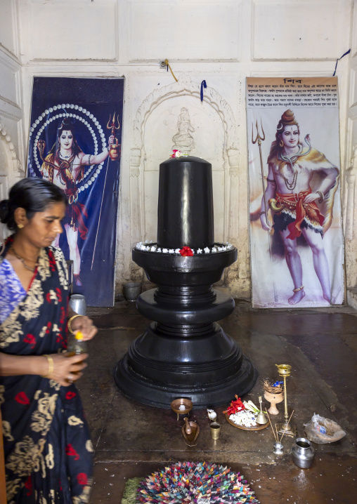 Woman making offerings to Shiva linga in Shiva temple, Rajshahi Division, Puthia, Bangladesh