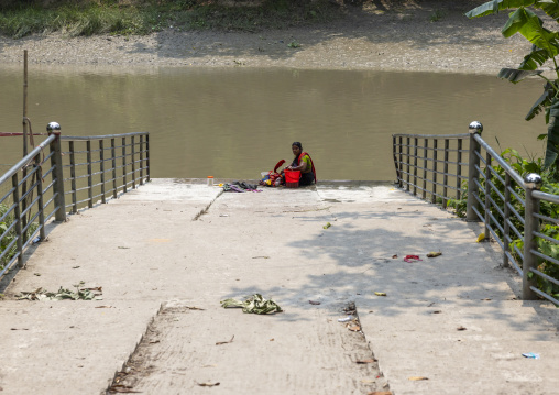 Bangladeshi woman washing clothes in a river, Khulna Division, Narail, Bangladesh