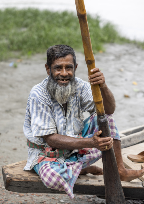 Smiling fisherman with his wooden oar on his boat, Khulna Division, Narail, Bangladesh