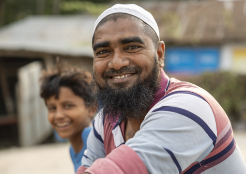 Smiling man with his son in the street, Barisal Division, Barisal, Bangladesh