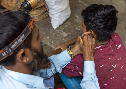 Man cleaning ear with cotton swabs in the street, Dhaka Division, Dhaka, Bangladesh