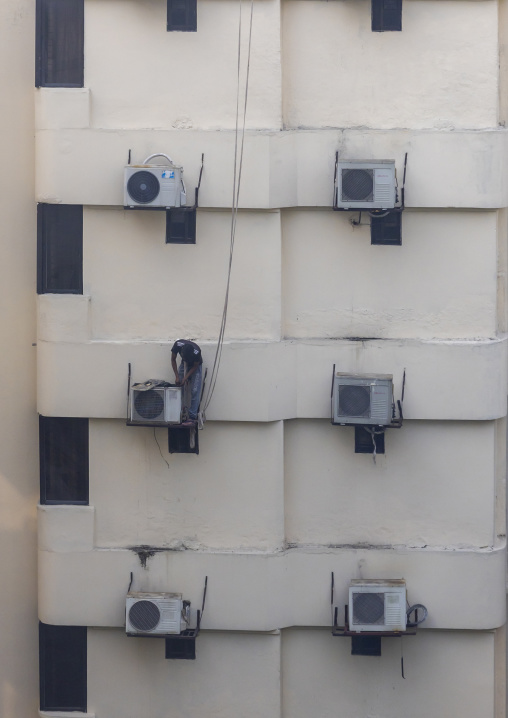 Air conditioning technician maintains air conditioning system, Dhaka Division, Dhaka, Bangladesh