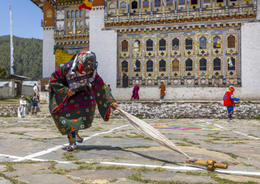 Masked atsara with a wooden phallus at Ura Yakchoe festival, Bumthang, Ura, Bhutan