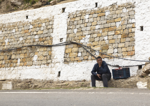 Bhutanese man sit on the roadside, Wangchang Gewog, Paro, Bhutan