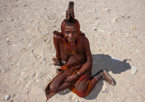 Himba woman sitting on the ground, Cunene province, Oncocua, Angola