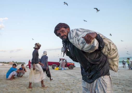 Old man taking a bag of sardine, Dhofar, Salalah, Oman