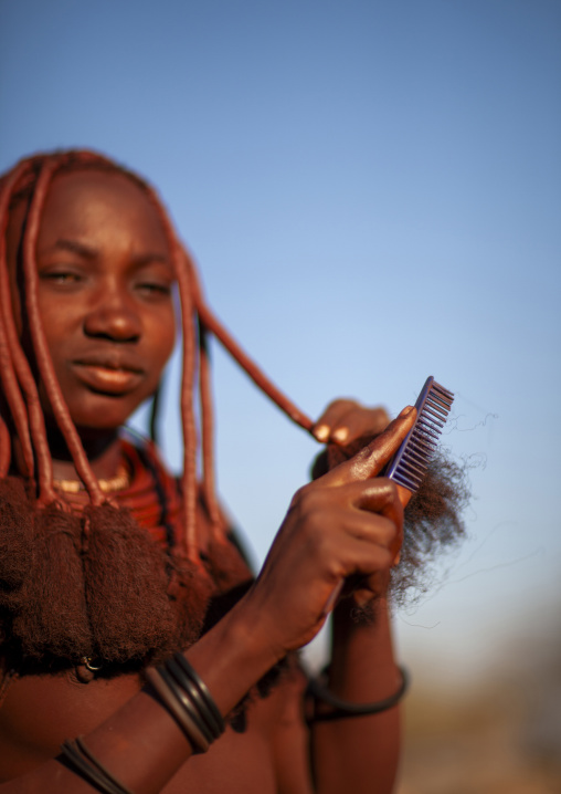 Young Himba tribe woman with traditional hairstyle, Omusati region, Ruacana, Namibia