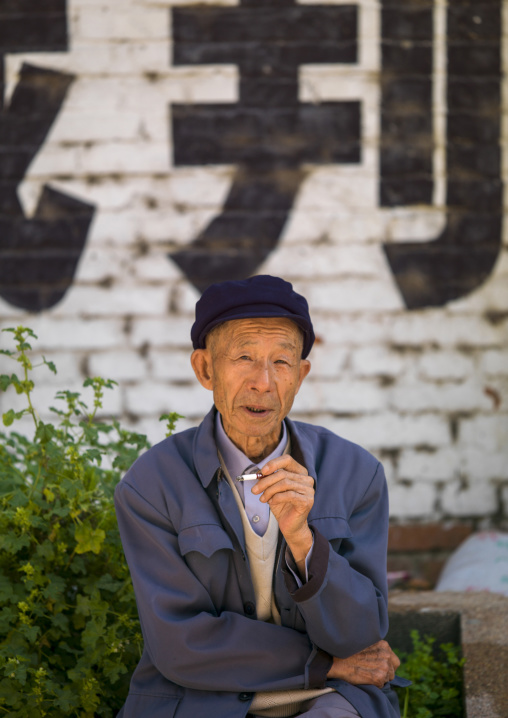 Old man sit in the street, Xizhou, Yunnan province, China