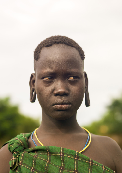 Portrait of a young surma tribe woman with enlarged ears, Tulgit, Omo valley, Ethiopia