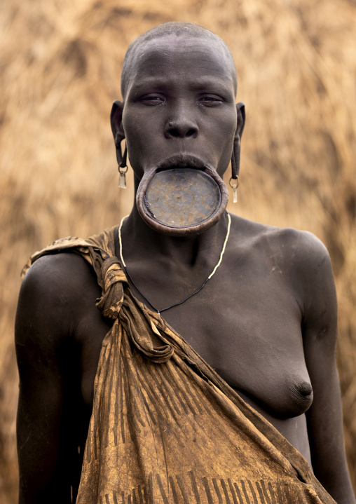 Mursi tribe woman with lip plate and enlarged ears, Mago national park, Omo valley, Ethiopia