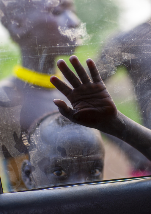 Bodi boy putting hand on car glass, Omo Valley, Hana Mursi, Ethiopia