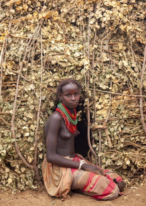 Dassanech teenage girl at entrance of her hut, Omo valley, Omorate, Ethiopia